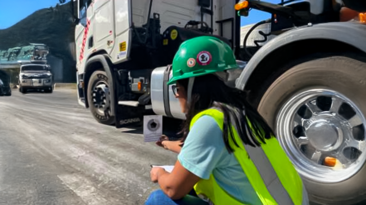 Colaboradora medindo a emissão de fumaça de um caminhão no terminal